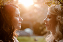 Two Sister Close-up Portraits At Sunset. Women Looking At Each Other