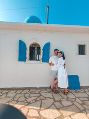 Wall Mural - couple travelers near old greece church