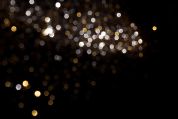 Wall Mural - golden and silver blurred bokeh lights on black background. glitter sparkle stars for celebrate. ove