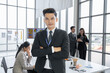 © SKW - Asian businessman looking at the camera Working and meeting at the office at the company with colleagues at the back