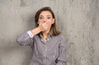 © rastockinc - Teenage woman covering mouth with hand on a gray wall