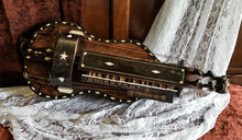 An Antique Musical Instrument Known As A Hurdy-Gurdy Shown On A Lace And Wood Background