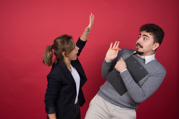 Wall Mural - Young woman trying to hit man with clipboard