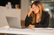 © ArLawKa - A stressed Asian accountant sitting in front of her laptop screen with her eyes closed at the desk. front view of a tired girl with eye strain sitting at a desk