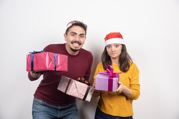 Wall Mural - Happy couple with Christmas gifts over a white wall