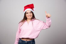 A Happy Woman In Santa Claus Red Hat Showing A Thumb Up
