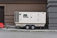 Heavy Diesel Electric Generator Stand On Trailer In Yard Office Building