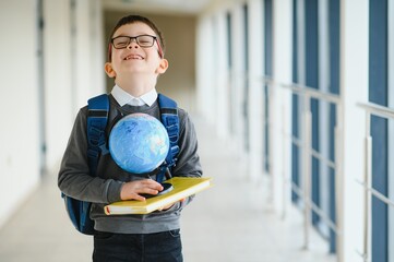 Wall Mural - Schoolboy with schoolbag and books in the school. Education concept. Back to school. Schoolkid going to class. Stylish boy with backpack. Boy ready to study.