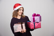 © rastockinc - Young woman with Santa hat holding gift boxes presents