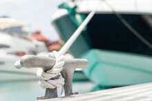 Mooring rope with a knot. Luxury yacht moored with a white rope to the pier in the marina