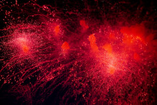 A Bright Firework With A Red Glowing Center With Red Sparks And Smoke Flying Towards The Background Of The Night Sky. High Quality Photo