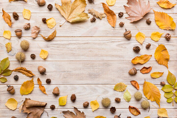 Wall Mural - Autumn composition made of dried leaves, cones and acorns on table. Flat lay, top view