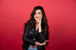 © rastockinc - Young woman posing with black glasses on a red background