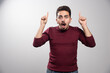 © rastockinc - A shocked brunette man showing fingers up and posing