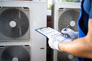 An Electrician Men Checking Air Conditioning Unit