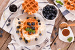 Waffles with blueberries and whipped cream.