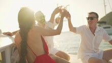 Caucasian Man And Woman Enjoy Luxury Outdoor Lifestyle Celebrating Holiday Party And Toasting Champagne Glass Together While Catamaran Yacht Boat Sailing In The Sea At Summer Sunset On Travel Vacation