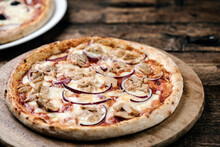 Pizza With Tuna And Red Onion On Wooden Cutting Board.
