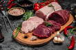 Different types of raw pork meat and beef on a dark background. various types of fresh meat pork and beef. Restaurant menu, dieting, cookbook recipe top view