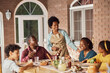 © Drazen - Cheerful African American extended family having fun during lunch on patio.