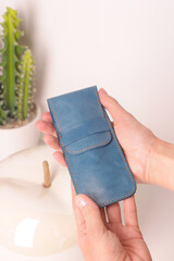 blue leather pen case for two pen in human hands closeup photo on white interior background