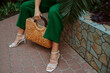 © Victoria Fox - Trendy summer straw wicker top handle bag, white strap sandals in stylish female outfit. Fashion details. Copy, empty space for text