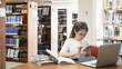 © 2April - Focused Asian Student Researching on Smartphone in University Library for Academic Success