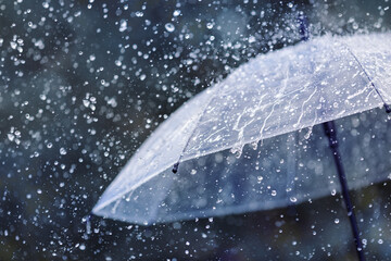 Wall Mural - transparent umbrella under heavy rain against water drops splash background. rainy weather concept.