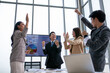 © todja - Asian business team celebrate corporate victory together in office, laughing and rejoicing, smiling excited employees colleagues screaming with joy in office.