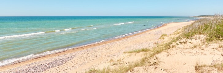 Wall Mural - Baltic sea shore on a sunny day. View from a sandy beach sand dunes). Clear blue sky, turquoise water. Idyllic seascape, landscape. Pure nature, ecology, eco tourism, vacations. Spring, early summer