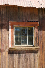 Closeup Of Abandoned Shed Window With Rusty Roof