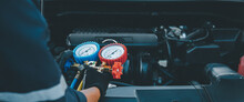 Close Up Hand Of Auto Mechanic Using Measuring Manifold Gauge Check The Refrigerant And Filling Car Air Conditioner For Fix And Checking For Repair Service Support Maintenance And Car Insurance.