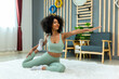 © kanpisut - Woman doing yoga at home in the living room. Woman is stretching in yoga at home. work out time
