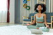 © kanpisut - Woman doing yoga at home in the living room. Woman is stretching in yoga at home. work out time
