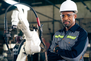 Poster - African American factory worker working with adept robotic arm in a workshop . Industry robot programming software for automated manufacturing technology .