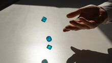 Woman Throws A Pair Of Blue Transparent Dice. 