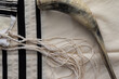 A shofar made from a lamb's horn placed on a tallit - the Jewish holiday of Rosh Hashanah