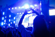 canvas print picture - Heart shaped hands at concert, loving the artist and the festival. Music concert with lights and silhouette of people enjoying the concert.