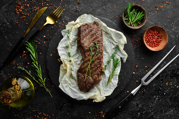 Beef Sirloin steak. Juicy cooked steak with rosemary and spices. Top view. Rustic style. Flat Lay.