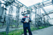 © Andrii - A masked power engineer during a pandemic inspects the modern equipment of an electrical substation before commissioning. Energy and industry. Scheduled repair of electrical equipment.