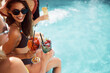 Cheerful woman toasting with her friends on summer day at the pool.