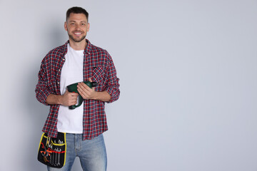 Sticker - Handsome worker with electric drill on white background, space for text