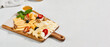 Cheese platter with nuts, honey sauce and olives on wood board. Cheeseboard on white concrete background. Cheese assorted in minimal style. Appetizers for wine.