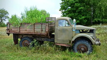 Old Truck In The Village With Growing Grass In The Back