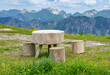 Urlaub im Kleinwalsertal, Österreich: Wanderung in der Nähe von Riezlern auf dem Grat zum Fellhorn - witziger Tisch und Stühle zur Rast aus Holz