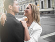 © Ulia Koltyrina - happy young blonde smiles and hugs her partner. A happy couple, a man and a woman on a city walk.