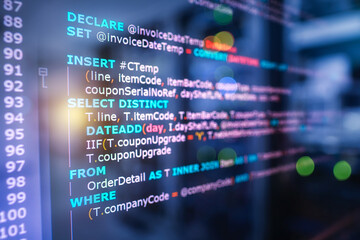 Wall Mural - sql (structured query language) code on computer monitor and server room background. example of sql 
