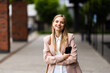 © F8  \ Suport Ukraine - Business woman standing outdoor near corporate office building hands folded on city street