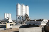 Fototapeta  - Scenery of concrete factory with white silos for production of concrete