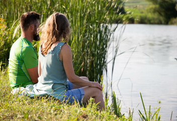 Poster - couple sitting by beautiful lake in the summer